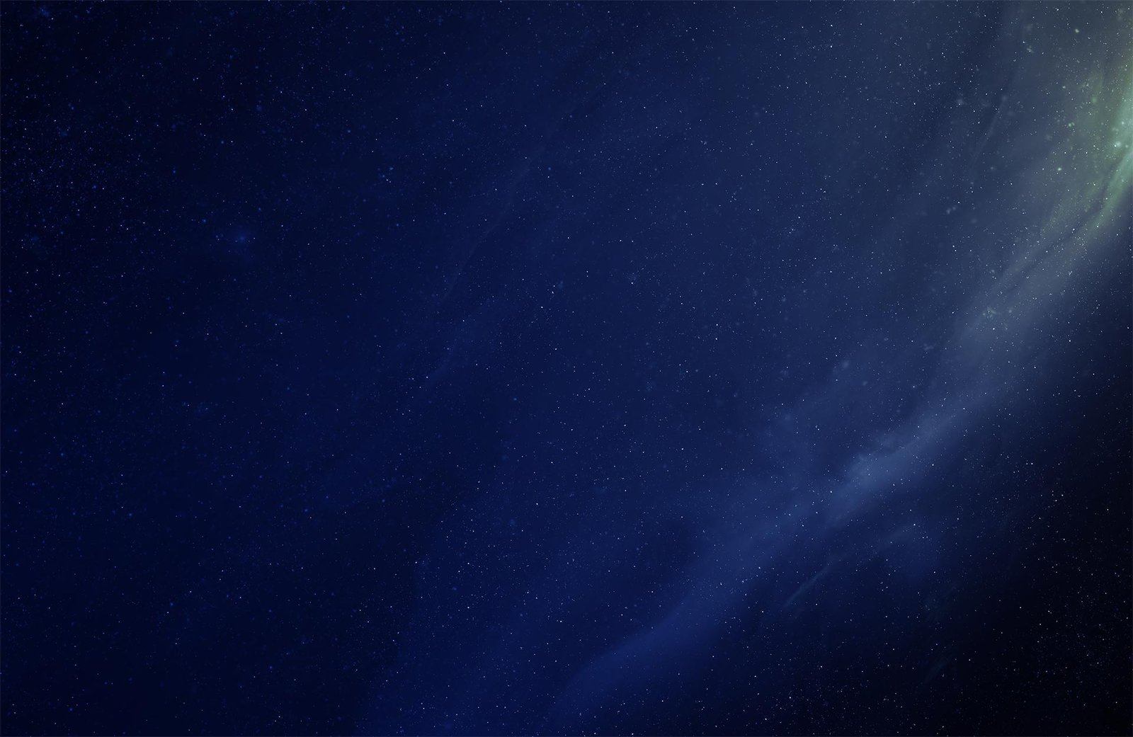 Starry night sky with a subtle green nebula glow in the corner